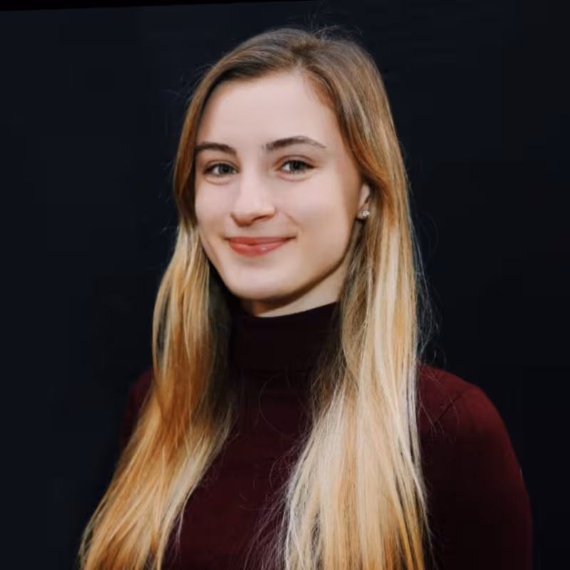 A blonde woman smiles confidently.
